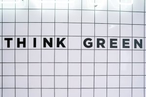 Modern wall art featuring the inspiring text 'Think Green' on a tiled background.
