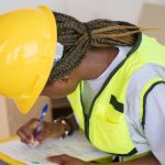 <h1>Engineering Resilience: The Role of Continual-Learning Causal Inference in Space Systems</h1> A female engineer in PPE writing on a clipboard at a construction site.