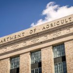 Close-up of the Department of Agriculture building facade under a clear blue sky.