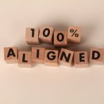 <h1>Federated Alignment and Value Learning: The Future of Personalized EdTech</h1> Wooden blocks spelling '100% Aligned' on a neutral background, conveying precision and alignment.