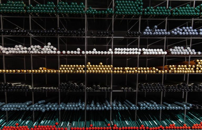 A vibrant assortment of colorful pens organized on shelves for a visually appealing stationery display.