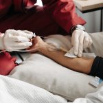 Few-Shot Hospital at Home: Scaling Remote Care With Less Data Paramedic in red uniform giving IV treatment to patient at home setting.