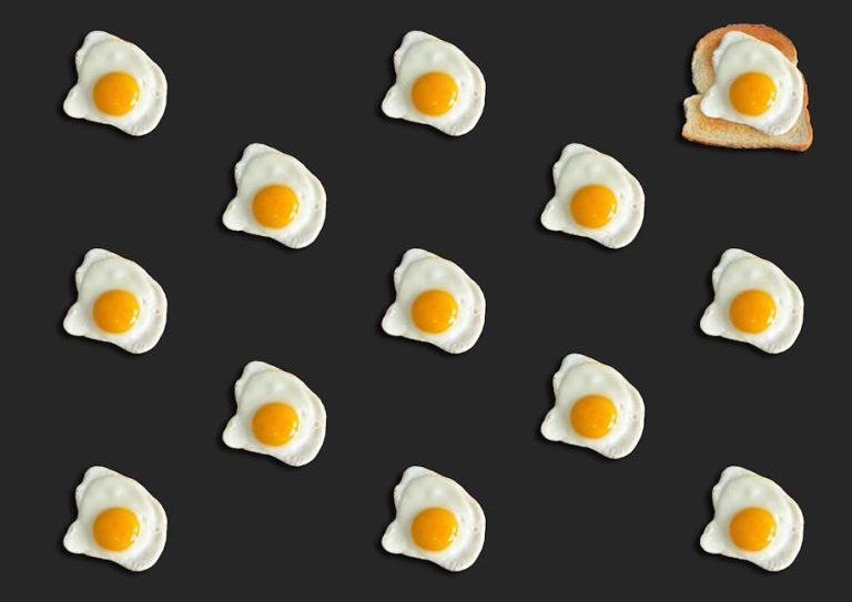 Creative pattern of fried eggs on black with toast, top view.
