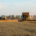 Future of Agritech: Multimodal Neuromorphic Chips & Algorithms Combine harvesters working in a golden wheat field during autumn.