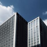 Tall skyscrapers with modern architecture reaching into a clear blue sky.