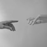 Human-In-The-Loop AI: A New Frontier for Neuroethics Black and white image of a human and robotic hand reaching towards each other, symbolizing connection.
