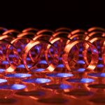 Dynamic abstract photo featuring glowing red rings against a vibrant blue background, creating an energetic pattern.