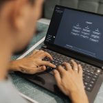 <h1>Human-In-The-Loop Brain-Computer Interfaces: Navigating the Neuroethical Frontier</h1> A focused individual types on a laptop running AI software indoors.