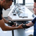 Engineer adjusts prosthetic arm for a patient in a modern lab setting.