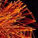Vibrant orange lines and dots form an abstract network on a dark background, evoking technology and connectivity.