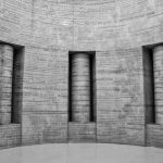 Grayscale photo of museum walls with various language texts engraved on them.