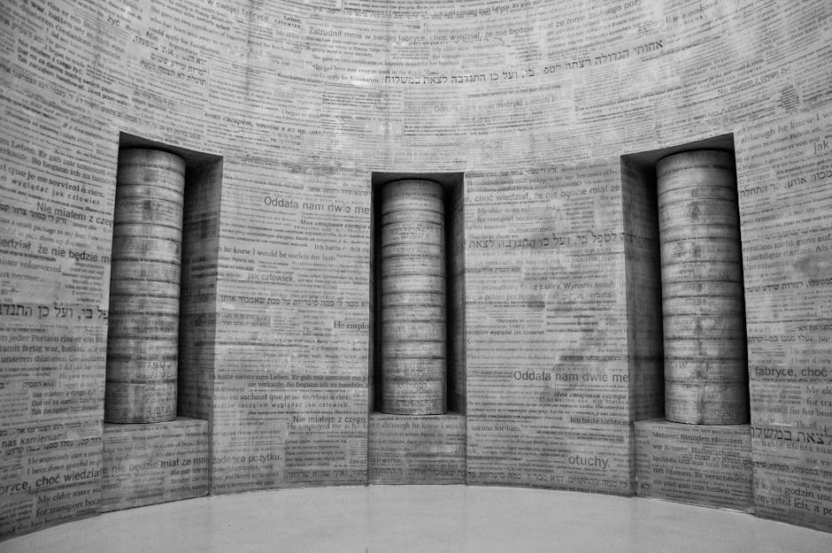 Grayscale photo of museum walls with various language texts engraved on them.