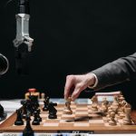 Language Intelligence: A Strategic Asset for Global Health Systems A robotic arm plays chess against a human, symbolizing AI innovation and strategy.