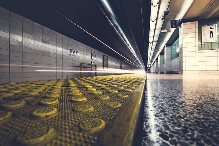 Low angle view of a fast-moving train at Bay Yorkville subway station with blurred motion.