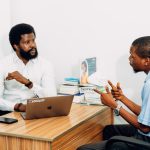 Medical History: Strategic Lessons for Modern Leaders Two adults engaged in a professional consultation in a Lagos office, discussing business or healthcare topics.
