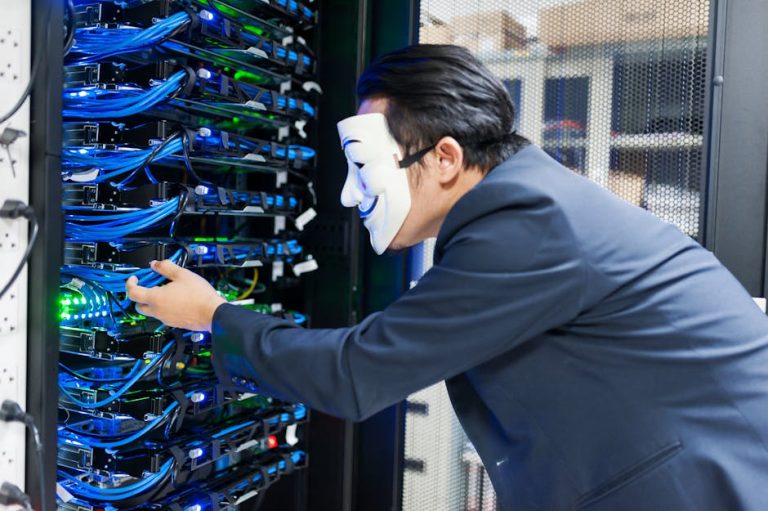 Masked individual interacting with server racks, symbolizing cybersecurity threats.