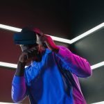 MHEA Metallurgy: Miniaturizing Next-Gen XR Hardware An adult man fully engaged in a virtual reality simulation with VR headset in a futuristic setting.