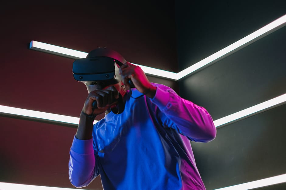 An adult man fully engaged in a virtual reality simulation with VR headset in a futuristic setting.