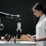 Multimodal Embodied Intelligence: The Future of Autonomous Ag A robot and woman engage in chess, showcasing technology and strategic thinking.