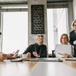 Business professionals discussing documents in a modern meeting room.