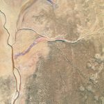 Breathtaking aerial photograph showcasing an arid desert with winding river captured from above.