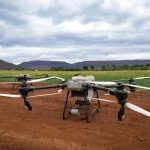 <h1>Open-World Precision Agriculture: The Future of Autonomous Agritech</h1> Aerial drones in a field, showcasing modern agricultural technology and landscape.