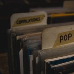 Optimizing Connectomics Compilers for Edge Cybersecurity A close-up of vinyl records categorized under 'POP' and 'COMPILATIONS' in a dimly lit retro store.