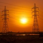 Optimizing Grid Resilience with Intent-Centric Networking (ICN) Silhouetted transmission towers under a vibrant sunset in Baghdad, Iraq.