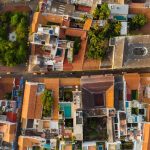 A vibrant aerial view of a bustling urban neighborhood with colorful rooftops and lush greenery.