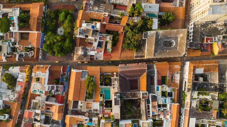 A vibrant aerial view of a bustling urban neighborhood with colorful rooftops and lush greenery.