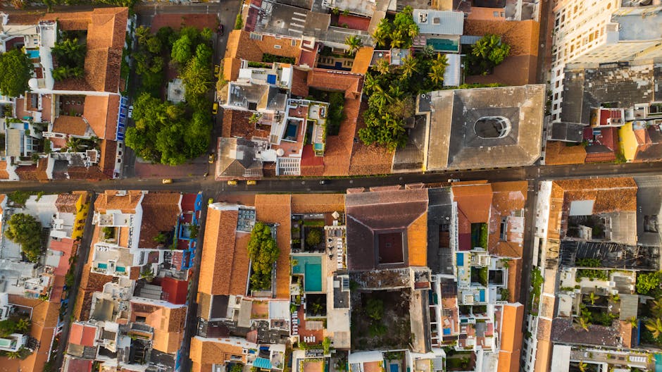 A vibrant aerial view of a bustling urban neighborhood with colorful rooftops and lush greenery.