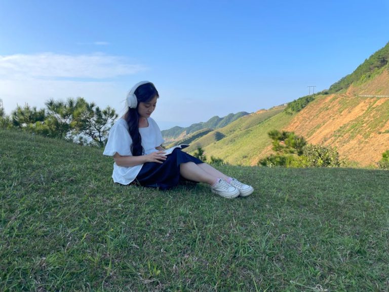 Young woman reading in a tranquil grassy landscape, Cao Lộc, Vietnam.