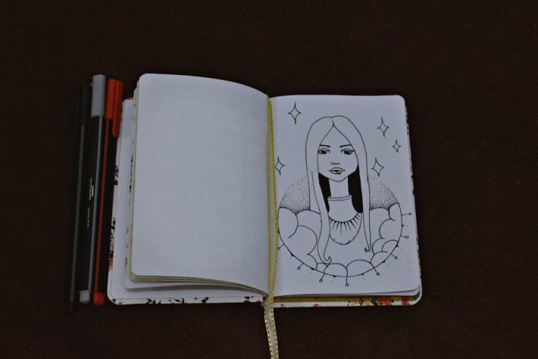 Artistic sketch of a woman in an open notebook with pens on a dark surface.