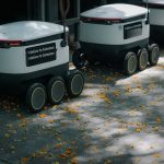 Physics-Informed Autonomous Logistics and Neuroethics Futuristic delivery robots navigating a leaf-strewn sidewalk, showcasing innovation in modern urban logistics.
