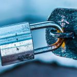 <h1>Physics-Informed Secure Multiparty Computation (PI-SMPC) in Biotechnology</h1> Detailed close-up of a durable padlock securing a rusted metal gate, emphasizing safety and protection.