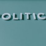 Close-up image of the word 'Politics' against a teal green background, highlighting political themes.