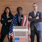Political Leadership as a Catalyst for Structural Opportunity Diverse group of political candidates standing with American flag at voting podium.