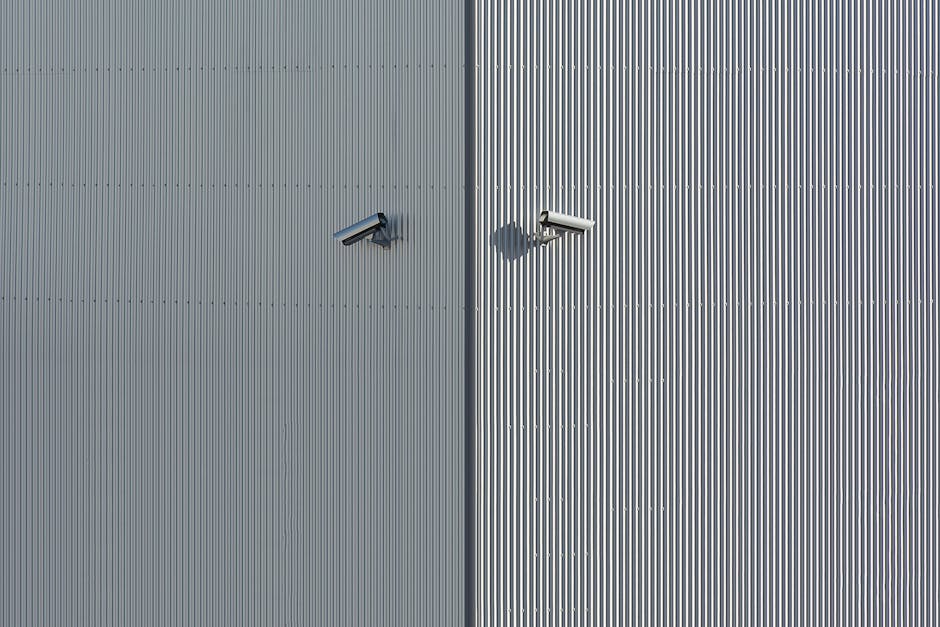 Corrugated metal wall with two mounted security cameras in a minimalist style.