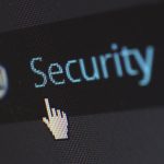 Close-up view of a mouse cursor over digital security text on display.