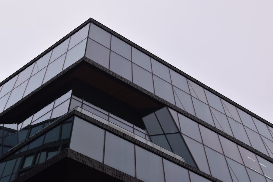 A striking modern building in Amsterdam with a reflective glass facade showcasing sleek architectural design.