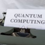 A vintage typewriter with a paper displaying the term Quantum Computing.
