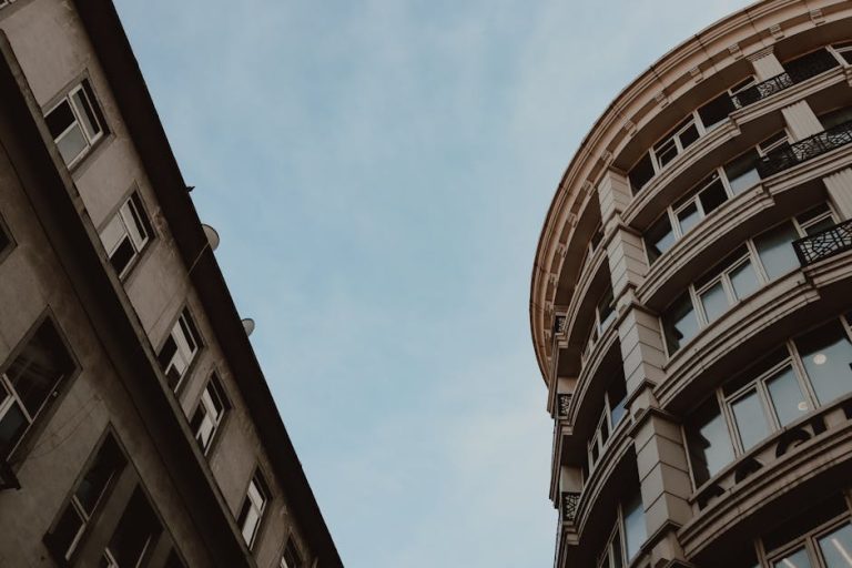Low angle view of modern city architecture against blue sky, highlighting geometric design.