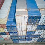 Aerial view showing colorful stacked cargo containers at a shipping yard.