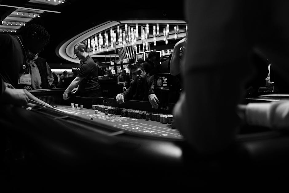 High-stakes gambling at a casino craps table in black and white.