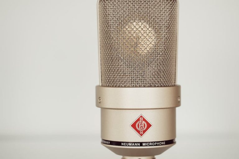 Close-up image of a vintage Neumann condenser microphone showcasing its metallic design.