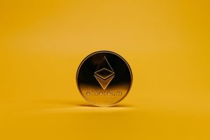 A shiny Ethereum coin displayed on a vibrant yellow background, symbolizing cryptocurrency.
