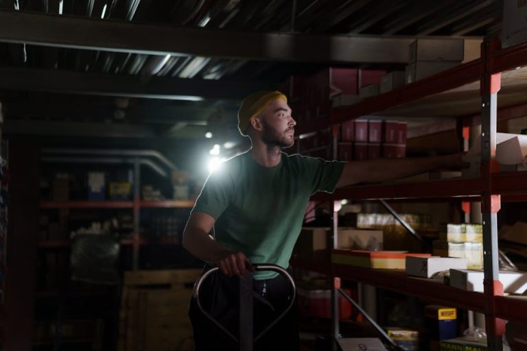 A dedicated worker organizing inventory on warehouse shelves with focused concentration.