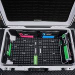 Top view of a neatly organized camera equipment hard case with labeled compartments.