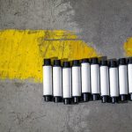 Safety-Aligned 2D Materials for Quantum Tech Plastic rolls aligned by a yellow road marking on concrete.