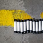 Safety-Aligned Protein Design: A Quantum Biotech Framework Plastic rolls aligned by a yellow road marking on concrete.